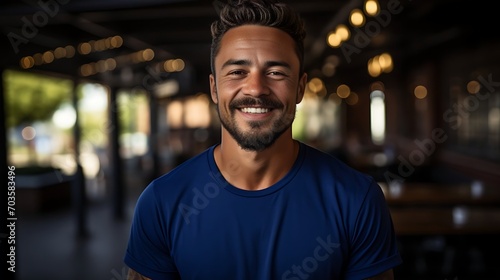Close up portrait of young smiling handsome guy in blue t-shirt isolated on a background