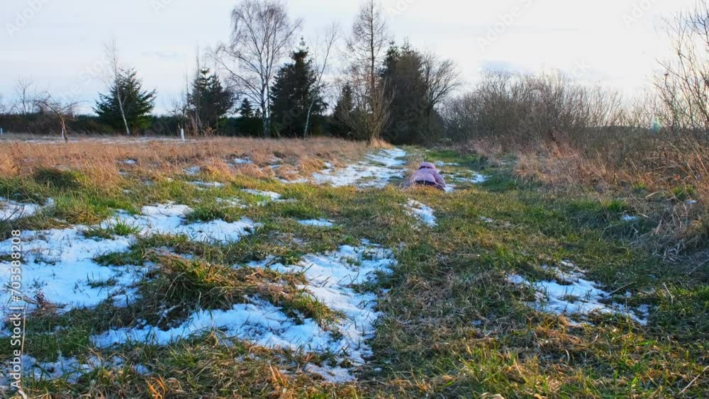 Funny Happy Kid in Warm Clothes Running Down Country Road Through Autumn Meadow Field Stumbling and Falling on Ground Funny Happy Kid in Warm Clothes Running Down Country Road Through Autumn Meadow Field Stumbling and Falling on Ground