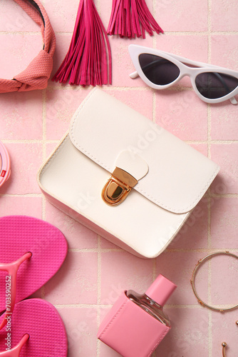 Stylish bag and different accessories on pink tile background