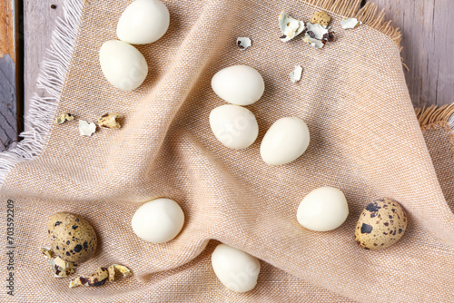 Boiled quail eggs with shells on grey wooden background