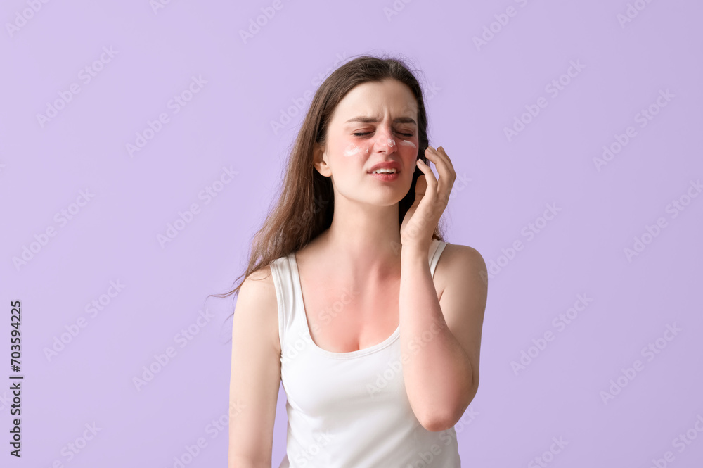 Allergic young woman with sunburned skin and cream on lilac background Allergic young woman with sunburned skin and cream on lilac background