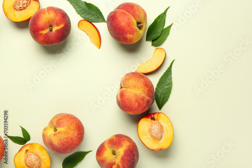 Frame made of sweet peaches and leaves on light background