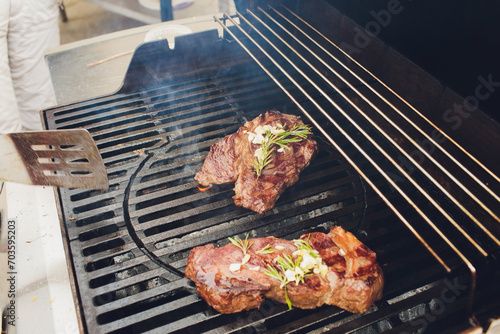 grilling steaks on flaming grill and shot with selective focus.