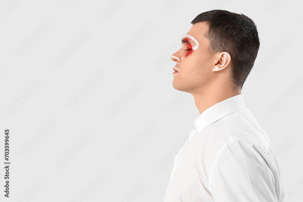 Handsome man with painted face on white background, closeup Handsome man with painted face on white background, closeup