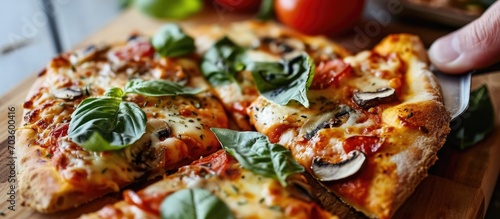 Hand holding vegetable pizza with mozzarella mushrooms cooked in an air fryer at home for breakfast or as a snack. photo