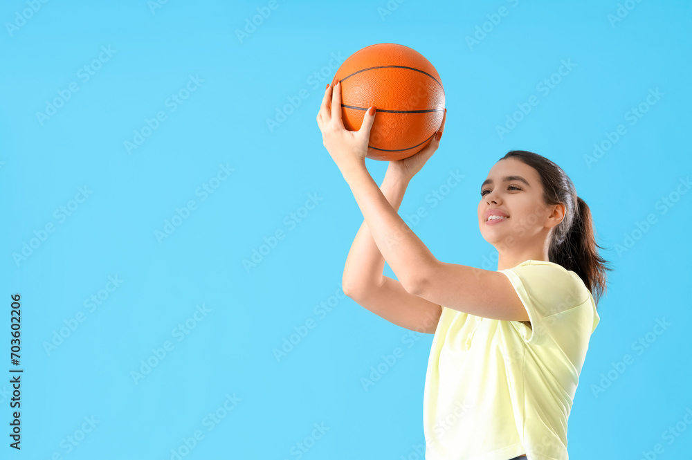 Young woman in sportswear with ball on blue background Young woman in sportswear with ball on blue background