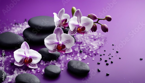 Spa Konzept - Violette Orchideen mit Basaltsteinen auf violettem Hintergrund