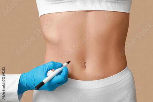 Young woman with flat belly and plastic surgeon on beige background, closeup