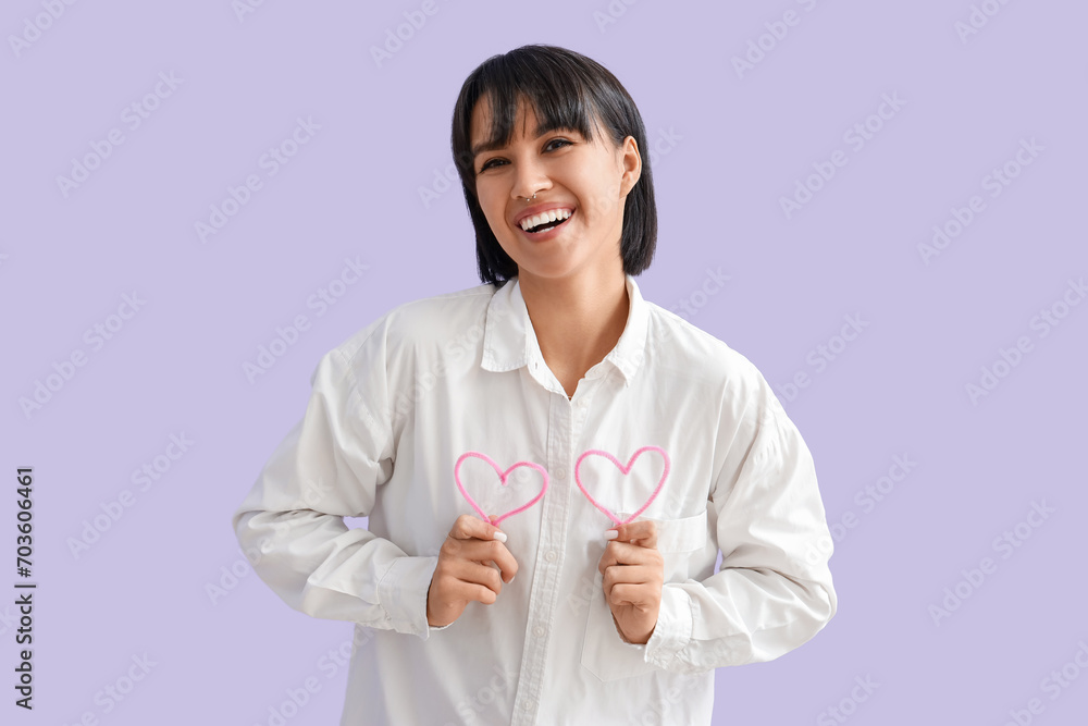 Beautiful young woman with decorative hearts on lilac background. Valentine's day celebration Beautiful young woman with decorative hearts on lilac background. Valentine's day celebration