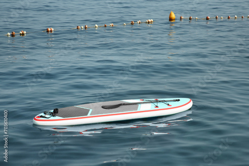 One SUP board with paddle on water in sea