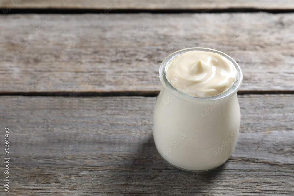 Fresh mayonnaise sauce in glass jar on wooden table, space for text Fresh mayonnaise sauce in glass jar on wooden table, space for text