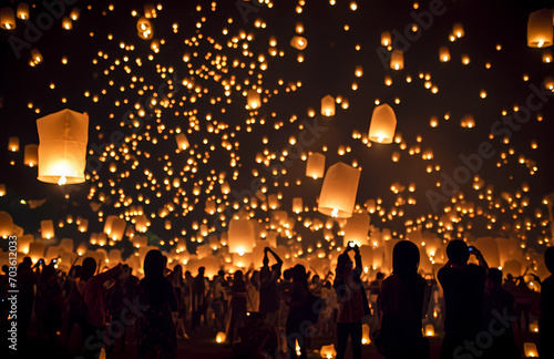 People in a crowd of lanterns flying in the air photo