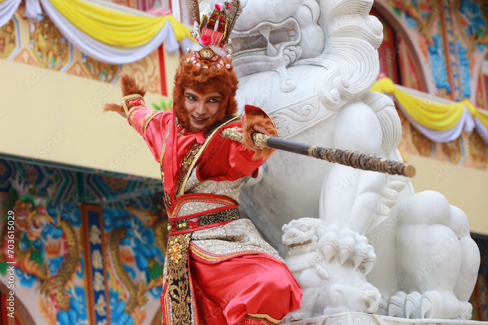 A young Asian man  dressed as a monkey king participates in the Chinese New Year parade, Chinese culture