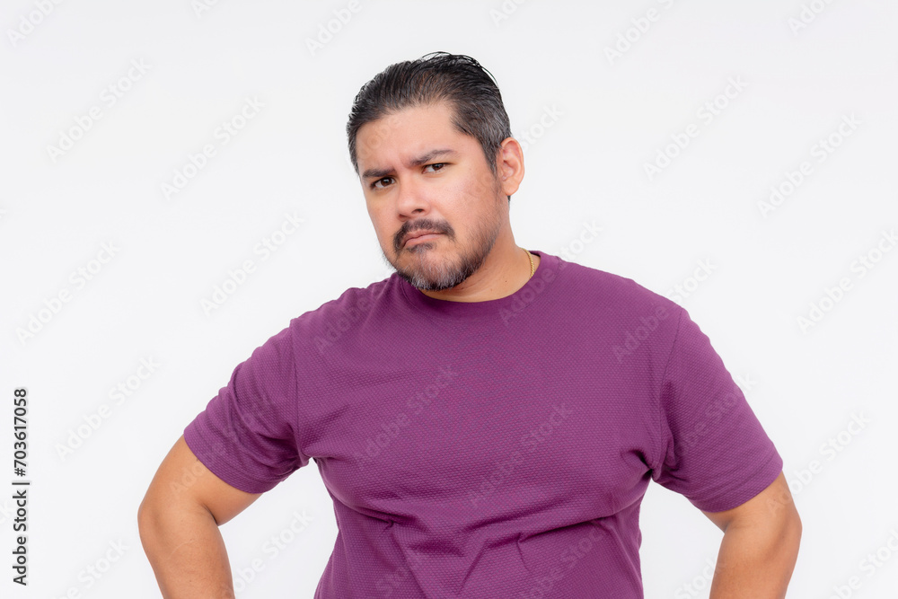 Obraz premium A wary middle aged man looks at someone with suspicioun. Wearing a purple waffle shirt, Isolated on a white background.