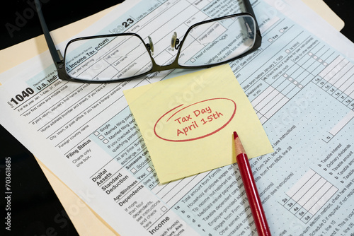 2024 US tax forms with taxes due date reminder and glasses on folder.