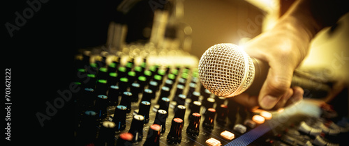 Schilderij op canvas Hand DJ holding microphone on sound mixer in live broadcasting studio producer for sound record control system production and audio equipment and music instrument speaker