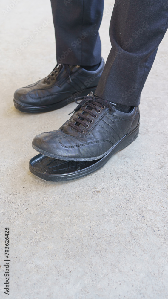 靴底(つま先)の剥がれた靴｜スーツの男性の足元