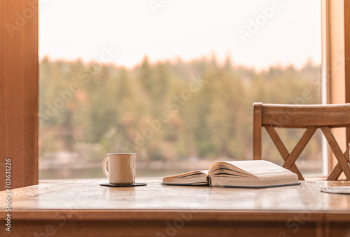 coffee cup on the table reading book by a window with relaxing nature view, concept morning leisure photo