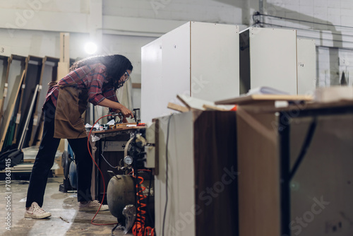 Carpenter working on woodworking machines in carpentry shop. Carpenter working to making wood furniture in wood workshop photo