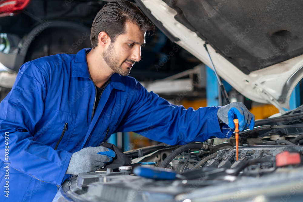 latin auto mechanic man checking car engine oil level in garage cars service . hispanic technician repairing vehicle at garage . maintenance latin auto mechanic man checking car engine oil level in garage cars service . hispanic technician repairing vehicle at garage . maintenance