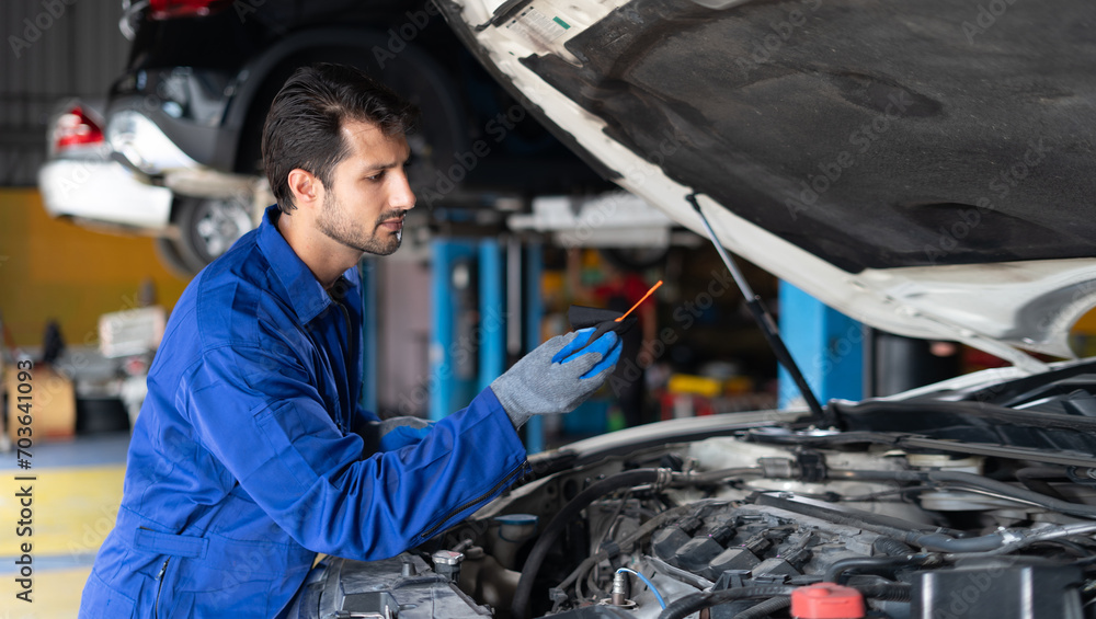 latin auto mechanic man checking car engine oil level in garage cars service . hispanic technician repairing vehicle at garage . maintenance latin auto mechanic man checking car engine oil level in garage cars service . hispanic technician repairing vehicle at garage . maintenance