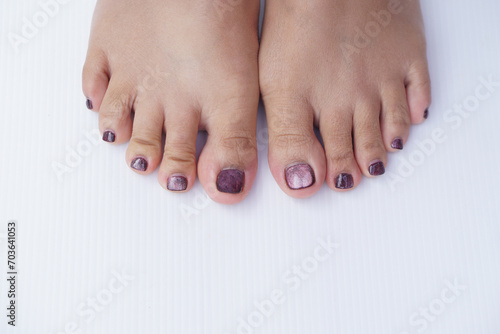 Close up polished nails and toes. White floor background. Concept, fashion and beauty on part of body. Nails polishment.