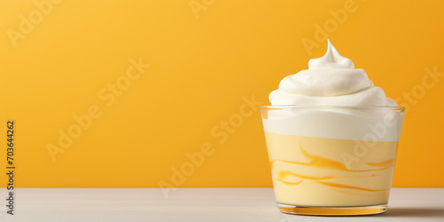 Alternating layers of soft yellow melon puree and vanilla whipped cream in a clear cup photo
