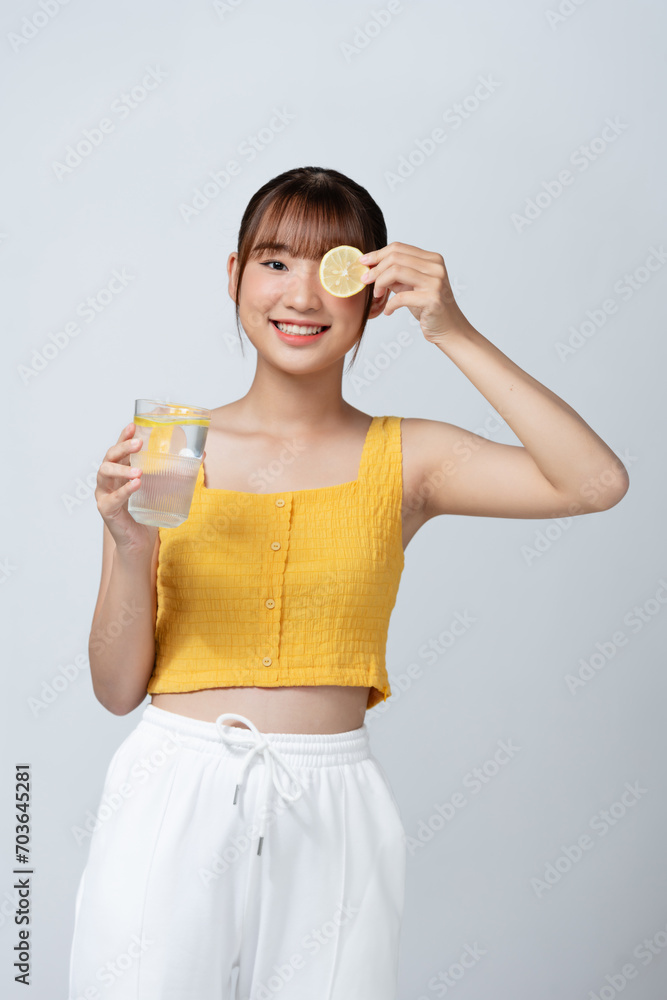 young woman holding lemon slice in front of eye young woman holding lemon slice in front of eye