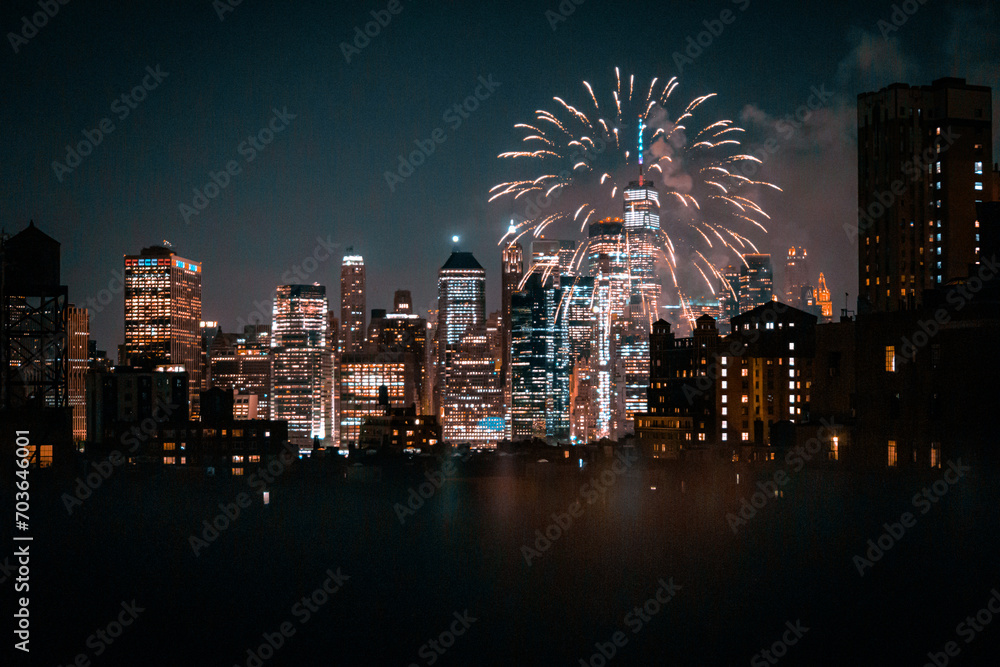 Fototapeta premium View of financial district Manhattan buildings and lights at night with fireworks at the sky