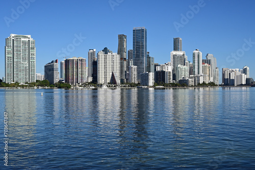 City of Miami  Florida skyline reflected in calm water of Biscayne Bay on calm cloudless December morning.