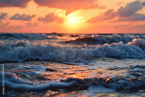 Close up of a vibrant sunset over the ocean with waves.