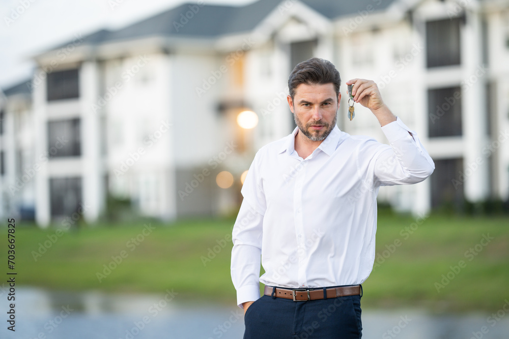 Businessman buying and selling houses and real estate. real state agent giving new house key. Estate agent with customer. man real state agent holds up a for sale sign and keys to the apartment. Businessman buying and selling houses and real estate. real state agent giving new house key. Estate agent with customer. man real state agent holds up a for sale sign and keys to the apartment.