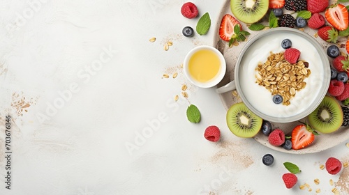 A top-down perspective of a delightful and healthy morning meal, showcasing a mix of granola, yogurt, berries, and a steaming cup of herbal tea with Copy space