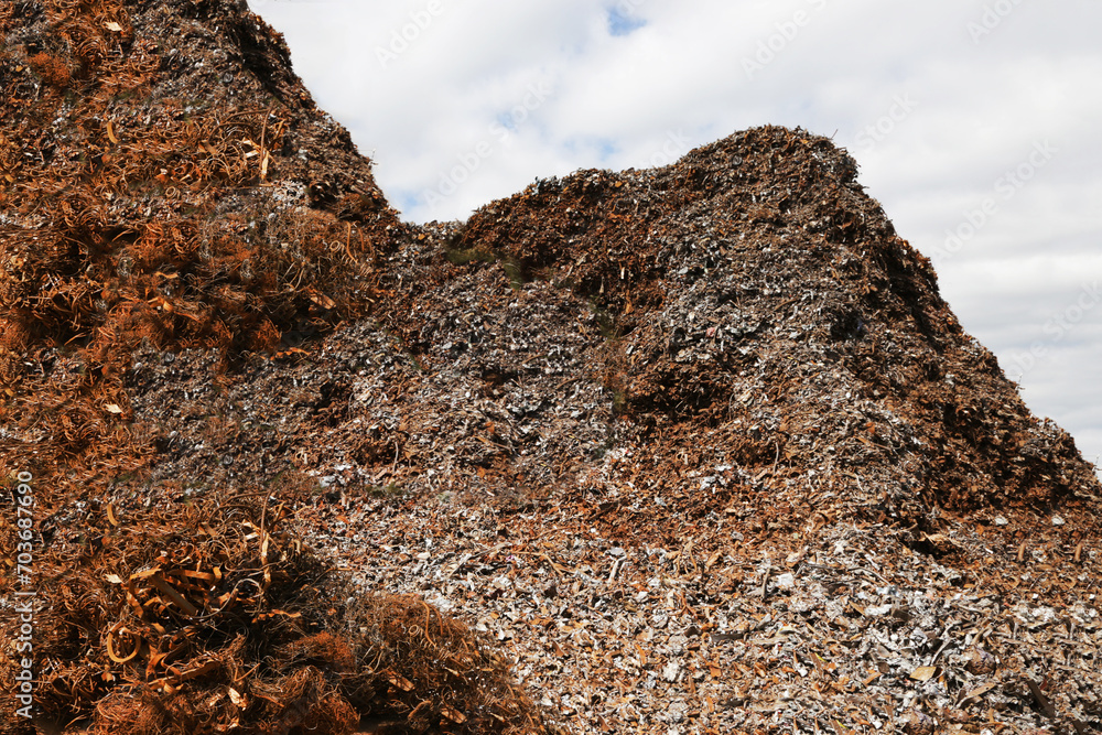 A large pile of rusty metal waste against the sky. A large pile of rusty metal waste against the sky.