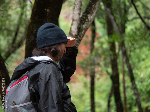 Wallpaper Mural Jeune campeur de profil, cherchant son chemin dans la forêt Torontodigital.ca