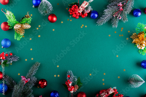 Green Christmas background with Christmas baubles, branches, mistletoe and little trees