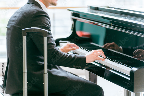 駅でピアノ・フリーピアノ・ストリートピアノを演奏するビジネスマン・ピアニスト 