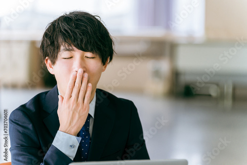 あくびをする若いビジネスマン
 photo