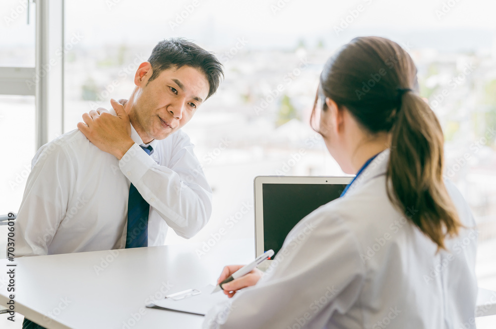 肩の痛みを医師に相談する中年男性（肩こり・四十肩・五十肩・過労）
