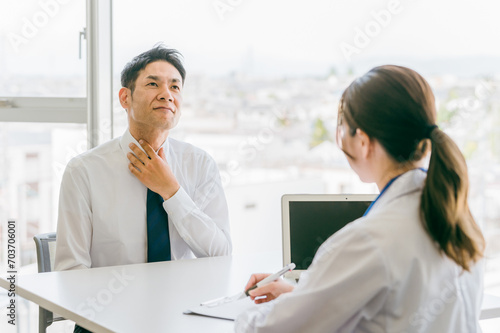 声の不調を医師に訴える中年男性（声帯・声帯炎・声帯ポリープ）
 photo