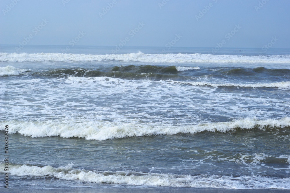 sea waves on a beach with black sand, holiday and vacation at summer