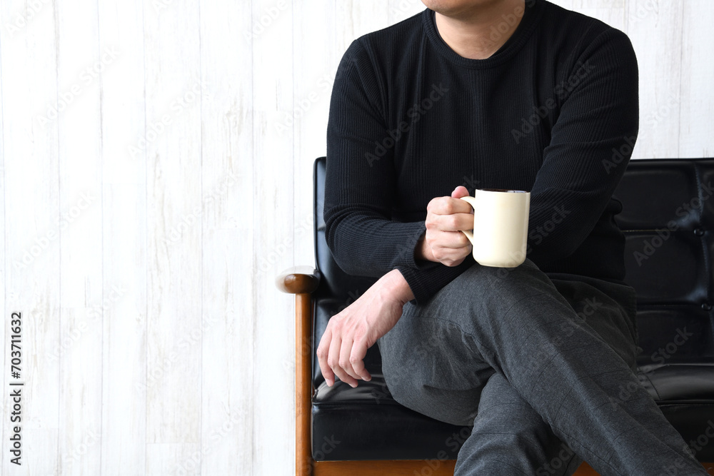 コーヒーカップを持ってリラックスする男性 コーヒーカップを持ってリラックスする男性