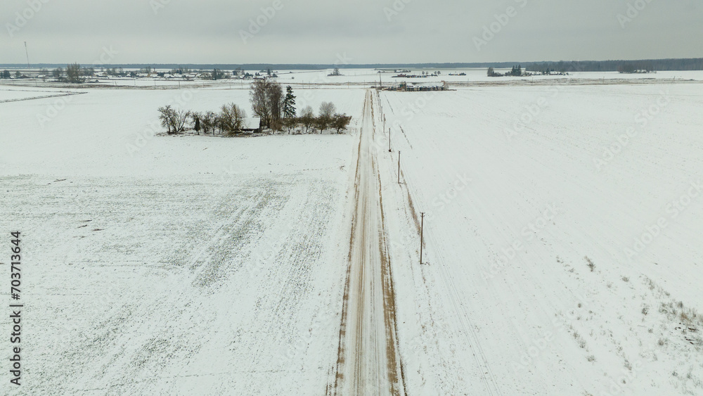 Drone photography of small rural dirt road during winter day