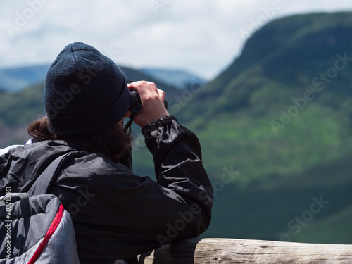 Randonneurs qui observe les montagnes vertes avec des jumelles  photo