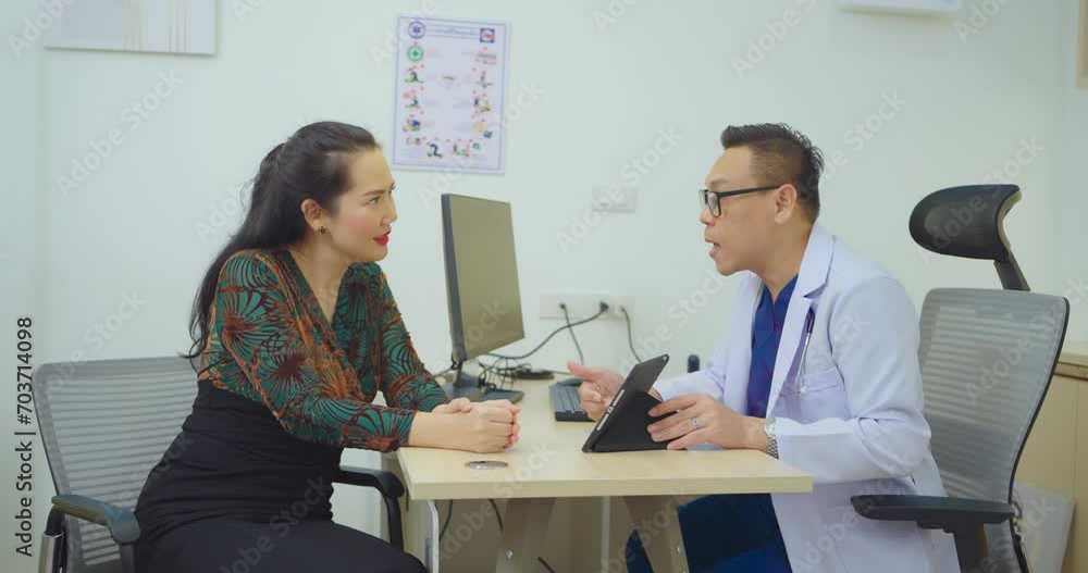 Male doctor talking with female patient at hospital room. They discussing about Illness with female patient at hospital. Male doctor talking with female patient at hospital room. They discussing about Illness with female patient at hospital.