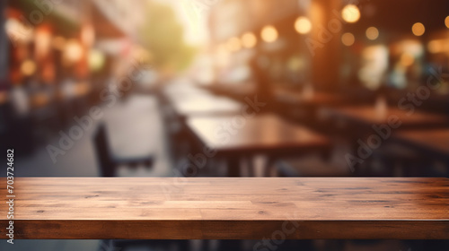 empty wood table top and blurred coffee shop and restaurant with lights © Aura
