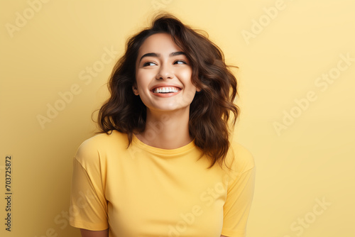 Photo of an happy woman wearing casual clothes. Portrait. Isolated on a yellow background. © Natawut
