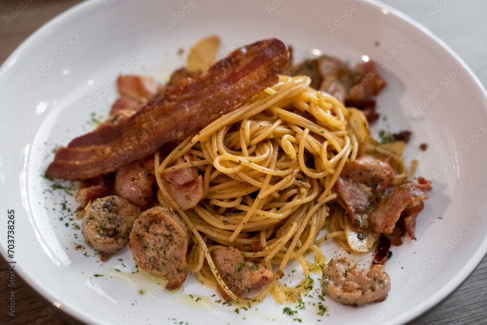 Spaghetti Aglio e Olio, garlic and olive oil, served with sausage and bacon Spaghetti Aglio e Olio, garlic and olive oil, served with sausage and bacon