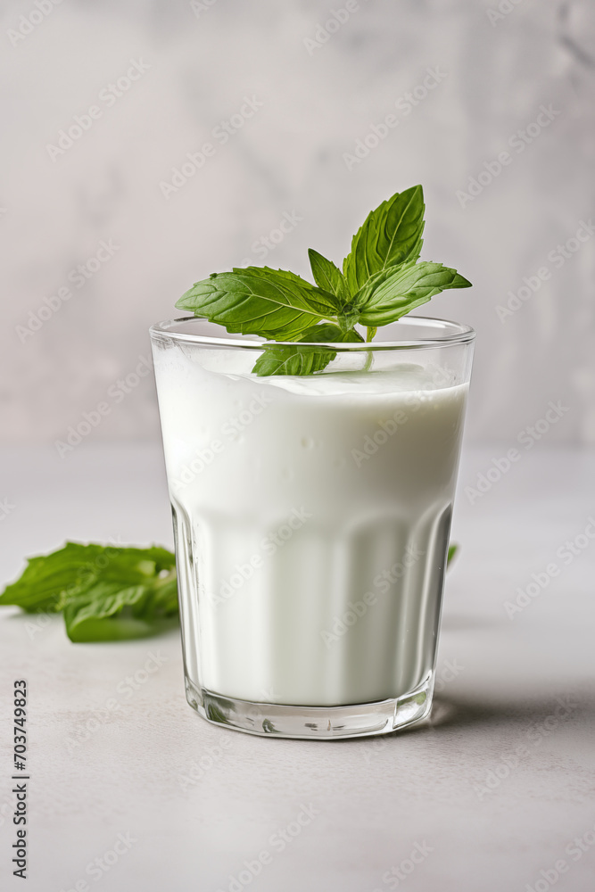 Ayran drink in glass on the light grey background Ayran drink in glass on the light grey background