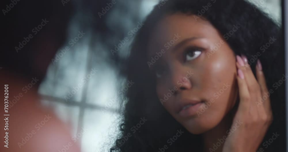Young black woman worried about the wrinkles on her face while standing in front of mirror. Young black woman worried about the wrinkles on her face while standing in front of mirror.